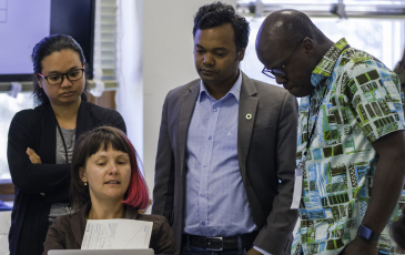 a group of people looking at a laptop