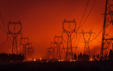 A photo of a fire occurring near or within electric lines 