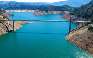 Suspension bridge crossing body of water with hills on sides